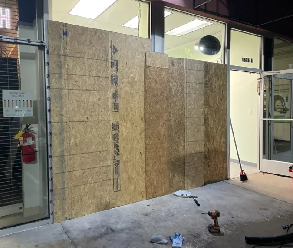 Plywood boards covering a storefront entrance.