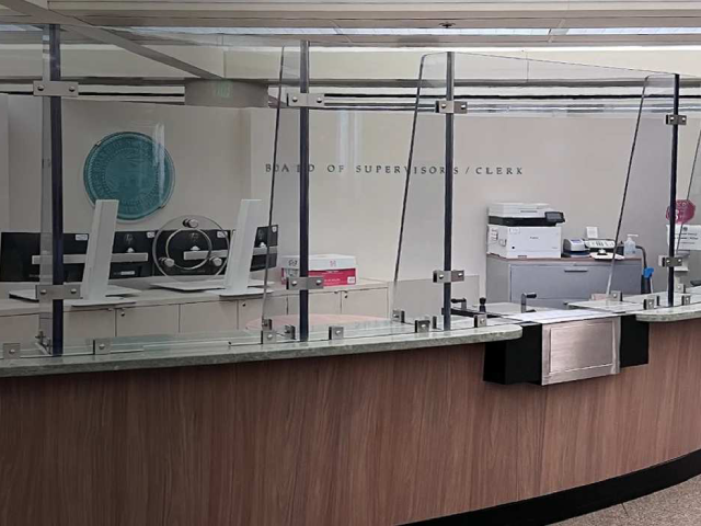 Office reception with protective glass barriers.